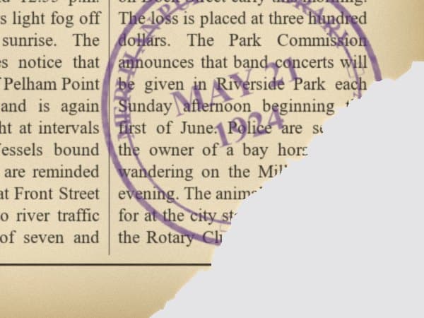 Torn corner on an old newspaper before restoration